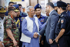 Bangladeshi Nobel laureate Muhammad Yunus, whom student leaders recommended as the head of the interim government, greets officials and security representatives on Aug. 8, 2024 as he arrives at Hazarat Shahjalal International Airport in Dhaka.