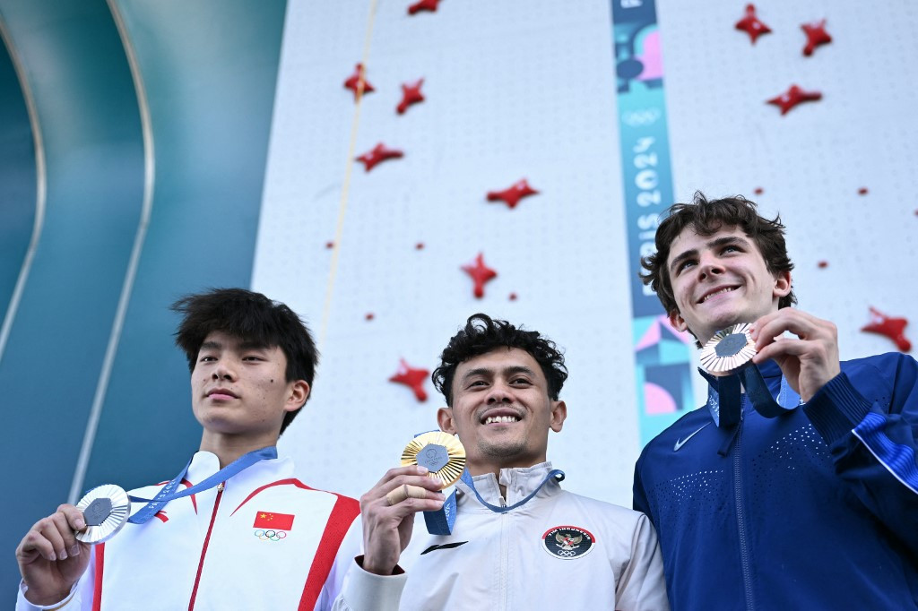 Gold medallist Indonesia's Veddriq Leonardo (center), silver medallist China's Wu Peng (left) and bronze medallist the United States' Sam Watson pose on the podium of the men's sport climbing speed event during the 2024 Olympic Games in Paris at Le Bourget Sport Climbing Venue in Le Bourget on Aug. 8, 2024.