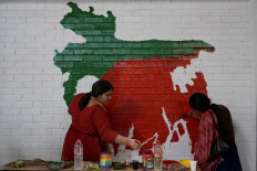 Students paint a Bangladesh map on a wall alongside a road after days of unrest in Dhaka on Aug. 9, 2024.