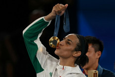 Gold medalist Algeria's Imane Khelif poses on the podium during the medal ceremony for the women's 66-kilogram final boxing category during the 2024 Olympic Games in Paris at the Roland-Garros Stadium, in Paris on Aug. 9, 2024.