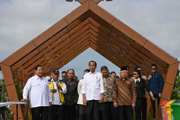 President Joko “Jokowi“ Widodo (center) and Vice President Ma'ruf Amin (second right) pose for a group photo with cabinet ministers and other ministerial-level officials while visiting a lake in Nusantara, East Kalimantan, on Aug. 12, 2024, before the first cabinet meeting in the planned future capital city.