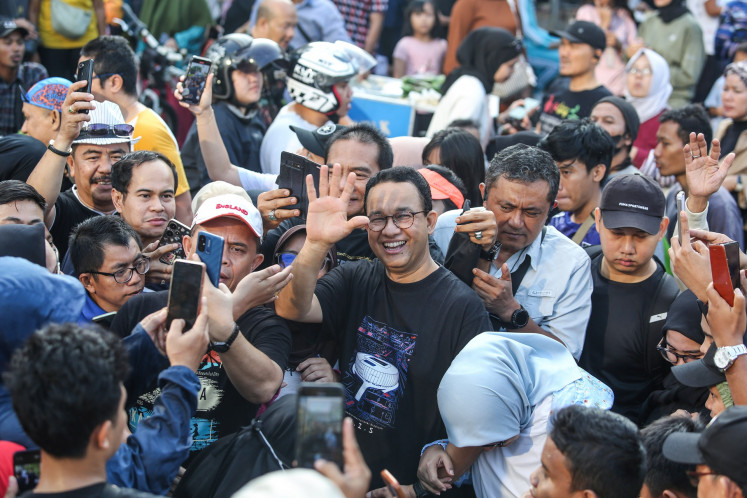 Former Jakarta governor Anies Baswedan (center) waves on Aug. 4, 2024 amid a crowd of people at car-free day event on Jl. Sudirman in downtown Jakarta.