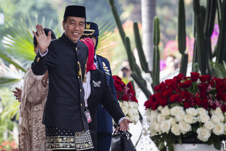 President Joko “Jokowi“ Widodo waves to reporters upon arriving at the Senayan legislative complex in South Jakarta ahead of his final State of the Nation address on Aug. 16, 2024.