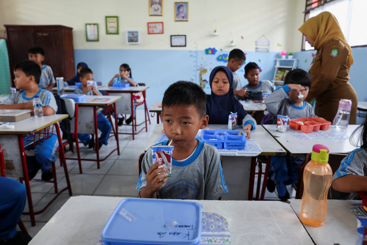 A student drinks milk that was distributed as part of a free school lunch trial on Aug.
5 at an elementary school in Tangerang, Banten.