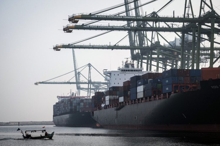 A small fishing boat sails on the waters near the New Priok Container Terminal One (NPCT1) in Cilincing, Jakarta, on Aug. 20, 2024.