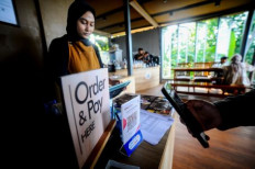 A customer scans a Quick Response Indonesia Standard (QRIS) code on July 7, 2024, to settle a transaction at Imah Kopi coffee shop in Gunung Karang, Pandeglang regency, Banten. 