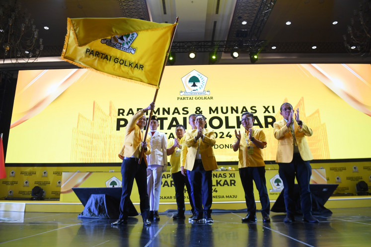 Golkar Party chairman Bahlil Lahadalia (left) waves the party flag after being inaugurated as the party chairman during Golkar national congress in Jakarta on Aug. 21, 2024.