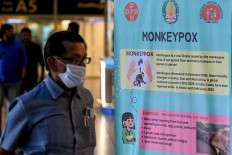 Passengers walk past the mpox awareness banner at Anna International Airport terminal in Chennai, India, on Aug. 21, 2024.