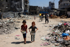 Palestinian children carry pots of soup near a food distribution point in the Jabalia refugee camp in northern Gaza Strip on Aug. 21, 2024, amid the ongoing conflict in the Palestinian territory between Israel and Hamas.