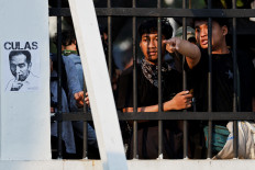 A demonstrator points as they clash with riot police during a protest against planned controversial revisions to election law outside the House of Representatives building in Jakarta, August 22, 2024. 