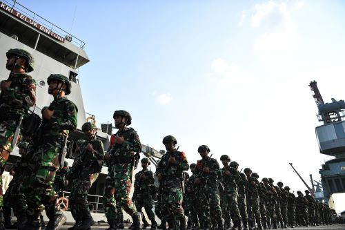 Troops of the Sriwijaya Military Command infantry battalion march past on July 21, 2024 after a ceremony at Boom Baru Port in Palembang, South Sumatra, to mark the deployment of soldiers to Papua.