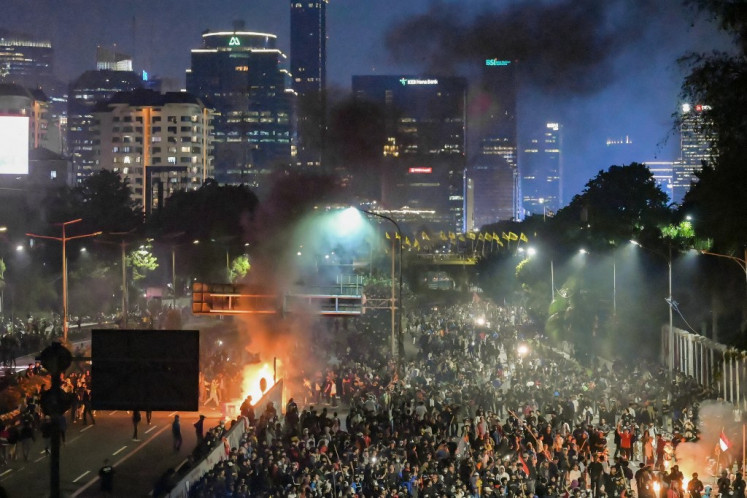 Demonstrators burn objects amid clashes outside the House of Representatives building in Jakarta on August 22, 2024 during a protest against a move to reverse the Constitutional Court's decision altering eligibility rules for candidates in a key election later this year. 