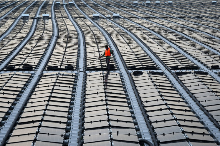 This photograph taken on Jan. 22, 2021 shows a worker pulling a cable along a floating solar power farm at sea off Singapore's northern coast just across from the Malaysian state of Johor. With huge data centers set to drive up already outsized energy demands, the tiny city-state of Singapore is looking to Australia's deserts and Malaysia's rainforests for clean power.