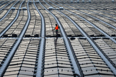 This photograph taken on Jan. 22, 2021, shows a worker pulling a cable along a floating solar power farm at sea off Singapore's northern coast just across from the Malaysian state of Johor.