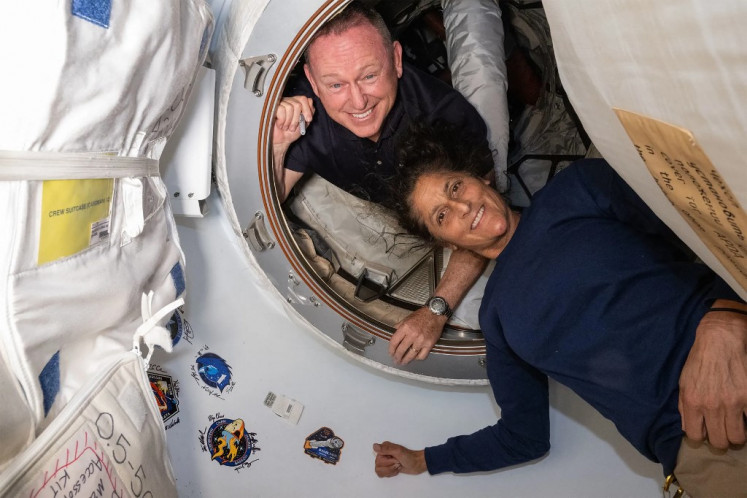 This undated handout picture from NASA released on July 2, 2024 shows NASA's Boeing Crew Flight Test astronauts (from top) Butch Wilmore and Suni Williams inside the vestibule between the forward port on the International Space Station's (ISS) Harmony module and Boeing's Starliner spacecraft.