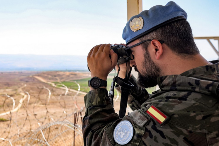 Seorang pasukan penjaga perdamaian dari Kontingen Spanyol melihat melalui teropong dari pos jaga di barak Pasukan Sementara Perserikatan Bangsa-Bangsa di Lebanon (UNIFIL) dekat Khiam di Lebanon selatan pada 23 Agustus 2024. Beberapa anggota Blue Helmets terluka dalam baku tembak antara Israel dan gerakan Hizbullah Lebanon, yang juga mengakibatkan puluhan warga sipil Lebanon tewas akibat perang antara Israel dan militan Palestina di Gaza.