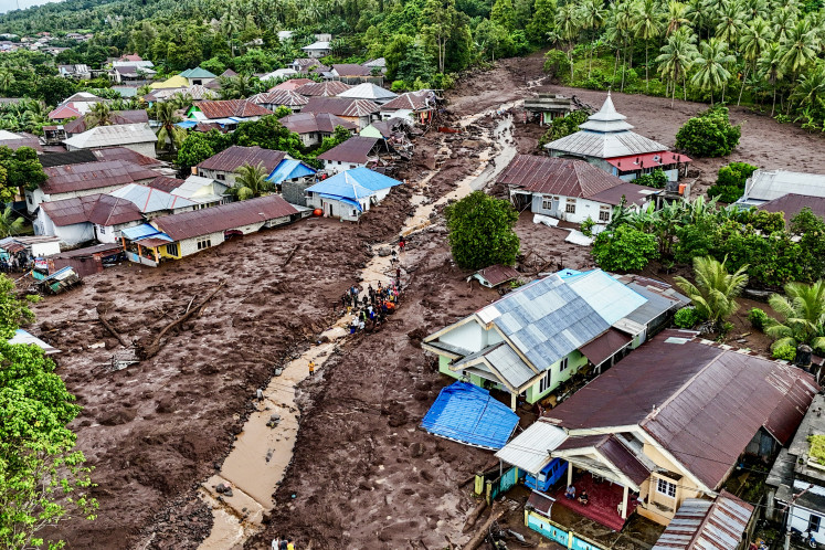 Pemandangan udara ini menunjukkan tim penyelamat dan warga mencari korban yang terkubur lumpur setelah banjir bandang melanda Desa Rua yang terletak di kaki Gunung Gamalama, di Ternate, Maluku Utara pada 25 Agustus 2024.  