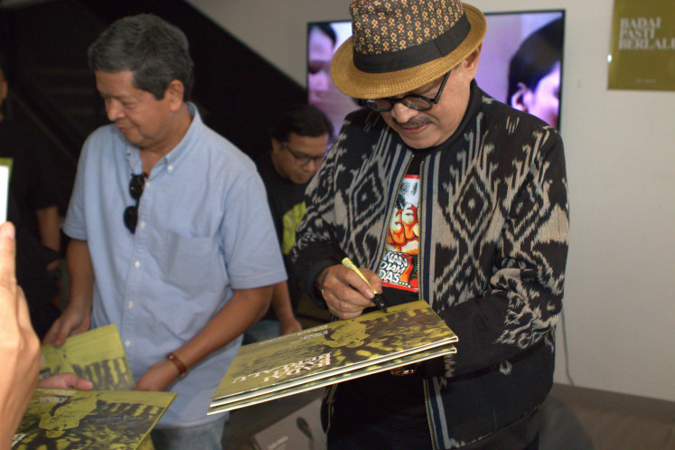 Making his mark: Famed composer Eros Djarot signs the vinyl reissue of the 1977 “Badai Pasti Berlalu“ soundtrack album for fans during its release on Sunday at Sonaa Space in Senayan Park, Central Jakarta.