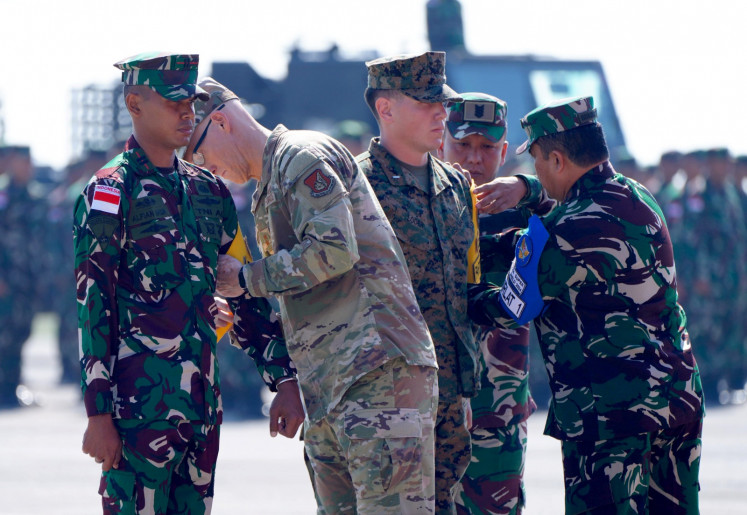 The Hawaii National Air Guard commander Maj. Gen. Joseph R. Harris II (second left) attaches participant armband to an Indonesian Military (TNI) personnel (left) while TNI Education and Training Command deputy commander Vice Marshal Widyargo Ikoputra (right) attaches the armband to a US military personnel (center) during the opening ceremony of the Super Garuda Shiled multinational joint exercise in Situbondo, East Java, on Monday, Aug. 26, 2024. The multinational joint exercise runs until Sept. 6.