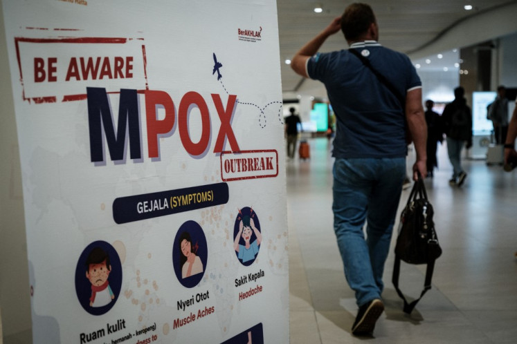 A passenger walks past a banner informing about mpox at Soekarno-Hatta International Airport in Tangerang, Banten on Aug. 26, 2024. Formerly known as monkeypox, mpox is an infectious disease caused by a virus transmitted to humans by infected animals that can also be passed from human to human through close physical contact.