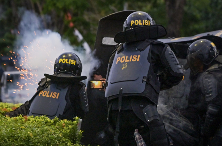 Police officers use tear gas to disperse protesters during a demonstration against a House of Representatives plan to revise the Regional Elections Law, in front of West Nusa Tenggara legislative council in Mataram on Aug. 23, 2024.