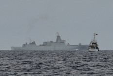 A vessel identified by the Philippine Coast Guard as a Chinese navy ship (background center) is seen past the Philippine Coast Guard ship BRP Cape Engano (right), during a supply mission to Sabina Shoal in disputed waters of the South China Sea on August 26, 2024. Sailors aboard two Philippine Coast Guard vessels crashed through South China Sea waves trying to bring food and other supplies to colleagues holed up inside a remote ring of reefs, as Chinese ships shadowed them. 