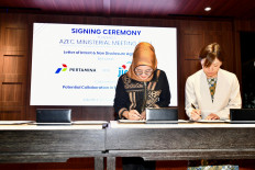 Pertamina finance director Emma Sri Martini and JICA chief representative Takeda Sachiko sign a letter of intent (LOI) for potential energy transition cooperation in Indonesia.