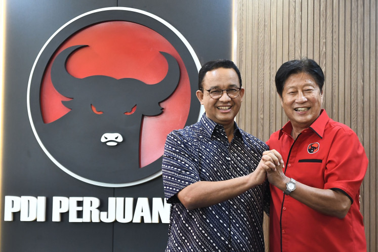 Former Jakarta governor Anies Baswedan (left) poses with Indonesian Democratic Party of Struggle's (PDI-P) Jakarta branch chair Ady Wijaya (right) following a meeting at the branch chair office in East Jakarta on Aug. 24, 2024.