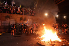 Israeli police officers face protesters during an anti-government rally calling for the release of Israelis held hostage by Palestinian militants in Gaza since October, on a highway in Tel Aviv on September 1, 2024. Families of Israeli hostages have called for a nationwide general strike starting September 1 night to force the government to reach a deal to secure the release of captives still held in Gaza. 