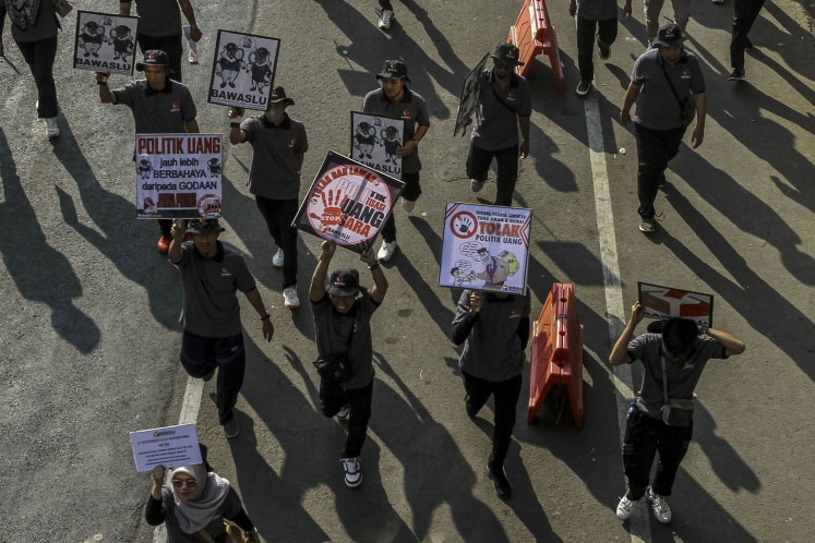 Officials of the Banten Elections Supervisory Agency (Bawaslu) hold banners during a march to promote the upcoming gubernatorial election, slated for Nov. 27, in Serang, Banten, on Aug. 31, 2024.