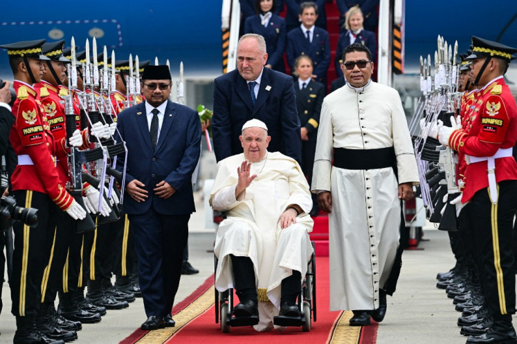 Pope Francis (center, in wheelchair) waves during his arrival at Soekarno-Hatta International Airport in Tangerang, Banten on Sept. 3, 2024. Pope Francis arrived in Muslim-majority Indonesia on Sept. 3 for the first stop of a four-nation tour in the Asia-Pacific that will be the longest of the 87-year-old's papacy.