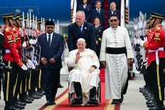 Pope Francis (center, in wheelchair) waves during his arrival at Soekarno-Hatta International Airport in Tangerang, Banten, on Sept. 3, 2024. Francis arrived in Muslim-majority Indonesia on Sept. 3 for the first stop of a four-nation tour in the Asia-Pacific that will be the longest of the 87-year-old's papacy.