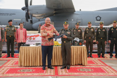 Indonesian Ambassador to Phnom Penh Santo Darmosusanto (center left) and Royal Cambodian Armed Forces vice commander-in-chief Gen. Mao Sophan pose with an SS2-V5 A1 assault rifle on Aug. 29, 2024 at Phnom Penh International Airport, during a ceremony to hand over US$500,000 in military aid from Indonesia.