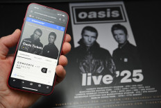 A fan uses a smart phone to access an online ticket sales website to purchase tickets for Oasis' “Live '25“ tour taking place in 2025, at home in Marsden, northern England on Aug. 31, 2024. Millions of Oasis fans queued online since early Aug. 31 to buy tickets for the British legends' eagerly-awaited reunion tour next year, but many were frustrated after booking websites appeared overwhelmed.