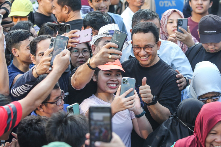 Anies Baswedan (center right) gives a thumbs-up on Aug. 4, 2024 as a crowd takes selfies with the former Jakarta governor during Car Free Day on Jl. Sudirman in Jakarta.