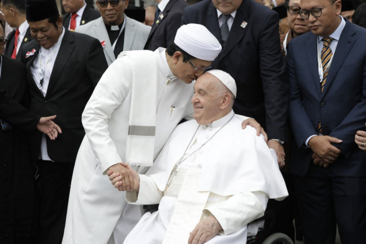 Istiqlal Mosque grand imam Nasaruddin Umar (left) shakes hands with Pope Francis during a family photo following an interreligious meeting with religious leaders at the Istiqlal Mosque in Jakarta on Sept. 5, 2024.