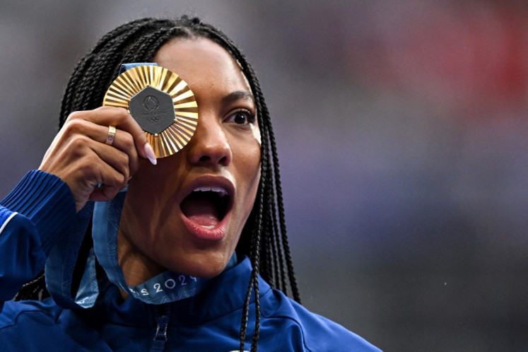 Peraih medali emas Tara Davis-Woodhall dari Amerika Serikat merayakan kemenangan di podium selama upacara kemenangan cabang atletik lompat jauh putri selama Olimpiade Paris 2024 di Stade de France di Saint-Denis, utara Paris, pada 9 Agustus 2024.