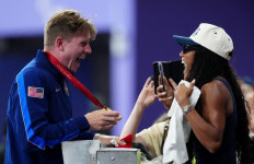 Gold medalist United States' Hunter Woodhall (left) celebrates with his wife Olympic women's long jump champion Tara Davis-Woodhall after the victory ceremony for the Men's 400 meters T62 final event at the Stade de France in Saint-Denis, outside Paris on Sept. 6, 2024.