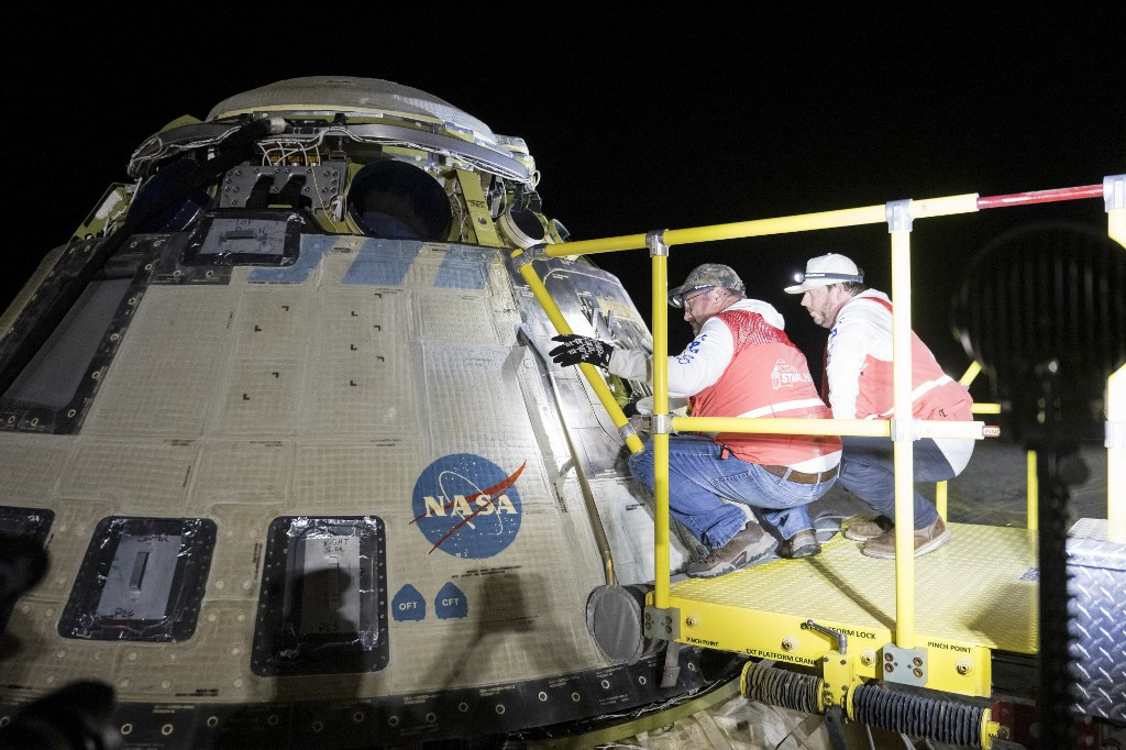 This handout image supplied by NASA shows Boeing and NASA teams work around NASA's Boeing Crew Flight Test Starliner spacecraft after it landed uncrewed at White Sands Space Harbor, on Sept. 6, 2024 at White Sands, New Mexico.