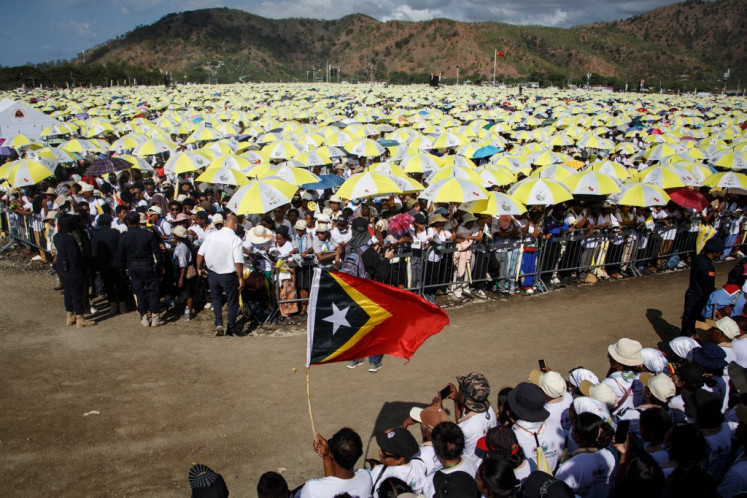 Umat ​​Katolik mengibarkan bendera nasional Timor Leste saat menunggu Paus Fransiskus memimpin misa kudus di Esplanade Tasitolu di Dili pada 10 September 2024.