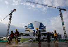 Workers clean the road near a construction site on Aug. 16, 2024, a day before the country's 79th Independence Day, in the future capital city of Nusantara in East Kalimantan. 