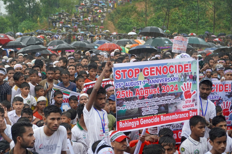 Rohingya refugees gather to mark the seventh anniversary of their fleeing from neighboring Myanmar to escape a military crackdown in 2017 during heavy monsoon rains in Cox's Bazar, Bangladesh on Aug. 25, 2024.