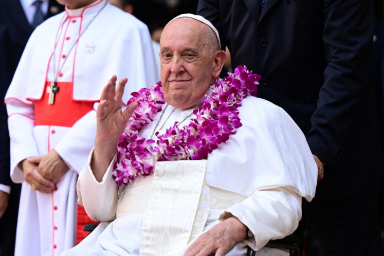 Pope Francis wears a flower garland as he arrives for an interreligious meeting with young people at the Catholic Junior College in Singapore on Sept. 13, 2024. Singapore is the last stop on the pope's 12-day, four-nation Asia-Pacific trip aimed at boosting the Catholic Church's standing in the world's most populous region.