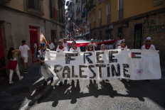 Members of “penas“ (festive groups) take part in a demonstration under the slogan “Free Palestine“ on their way to the bullring during the San Fermin festival in Pamplona, northern Spain, on July 11, 2024.