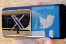 The logo of social media platform X is seen on a mobile phone next to a reflection of Brazil's Supreme Court in this illustration taken on Aug. 30, 2024, in Brasilia.