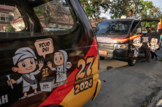 Officials with the Palu General Elections Commission (KPU) enter a car used in a parade to promote the 2024 simultaneous regional elections in Palu, Central Sulawesi, on Sept. 13, 2024.
