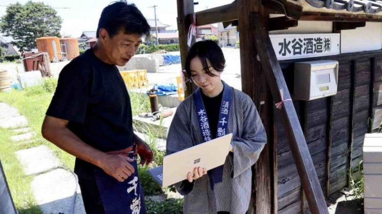 Staff member Miwa Goto (right) shows a spreadsheet of data input into the digital tool to Mizutani Shuzo President Masao Mizutani at the brewery in Aisai, Aichi prefecture, Japan.