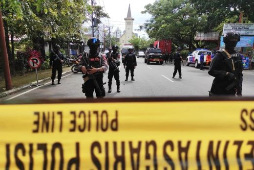 Blocking terror: The steeple of Makassar Cathedral rises behind a police cordon on an access road in South Sulawesi’s provincial capital on March 28, 2021, following a suicide bomb attack allegedly carried out by terror group Jamaah Ansharut Daulah.