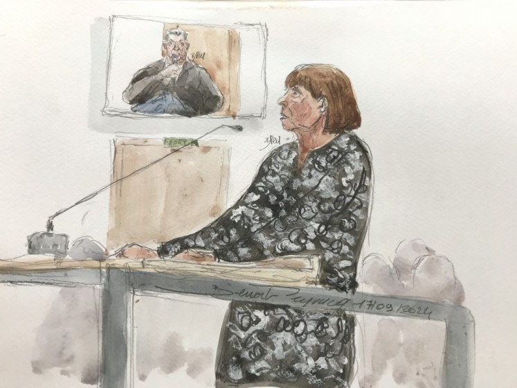 This court sketch created on Sept. 17, 2024, shows Gisele Pelicot (right) at the stand as defendant Dominique Pelicot (rear) is displayed on a monitor during his trial in which he is accused of drugging his wife so he and scores of strangers could rape her at their home in Mazan, a small town in the south of France, at the courthouse of Avignon in Avignon. A court in the southern town of Avignon is trying Dominique Pelicot, a 71-year-old retiree, for repeatedly raping and enlisting dozens of strangers to rape his heavily sedated wife in her own bed over a decade. Fifty other men, aged between 26 and 74, are also on trial for alleged involvement, in a case that has horrified France.