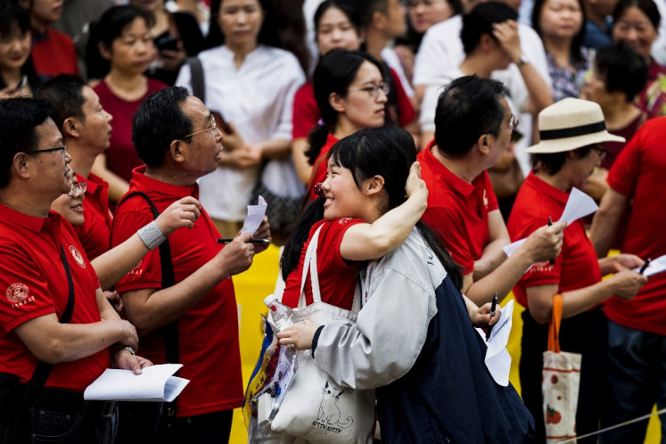 A student hugs a teacher outside a school on the first day of the national college entrance examination, known as “Gaokao“, in Wuhan, in central China's Hubei province on June 7, 2024.